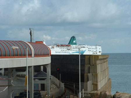 boat rounds the harbour wall